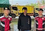 Petugas Polres Ogan Ilir mengamankan terduga pelaku premanisme di depan truk kuning, didampingi dua anggota berseragam merah-hitam.