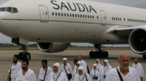 Jemaah haji berjalan di depan pesawat Saudia Airlines di bandara