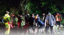 Petugas Satlantas dan warga gotong royong evakuasi pohon tumbang di jalan nasional Aceh Jaya pada malam hari